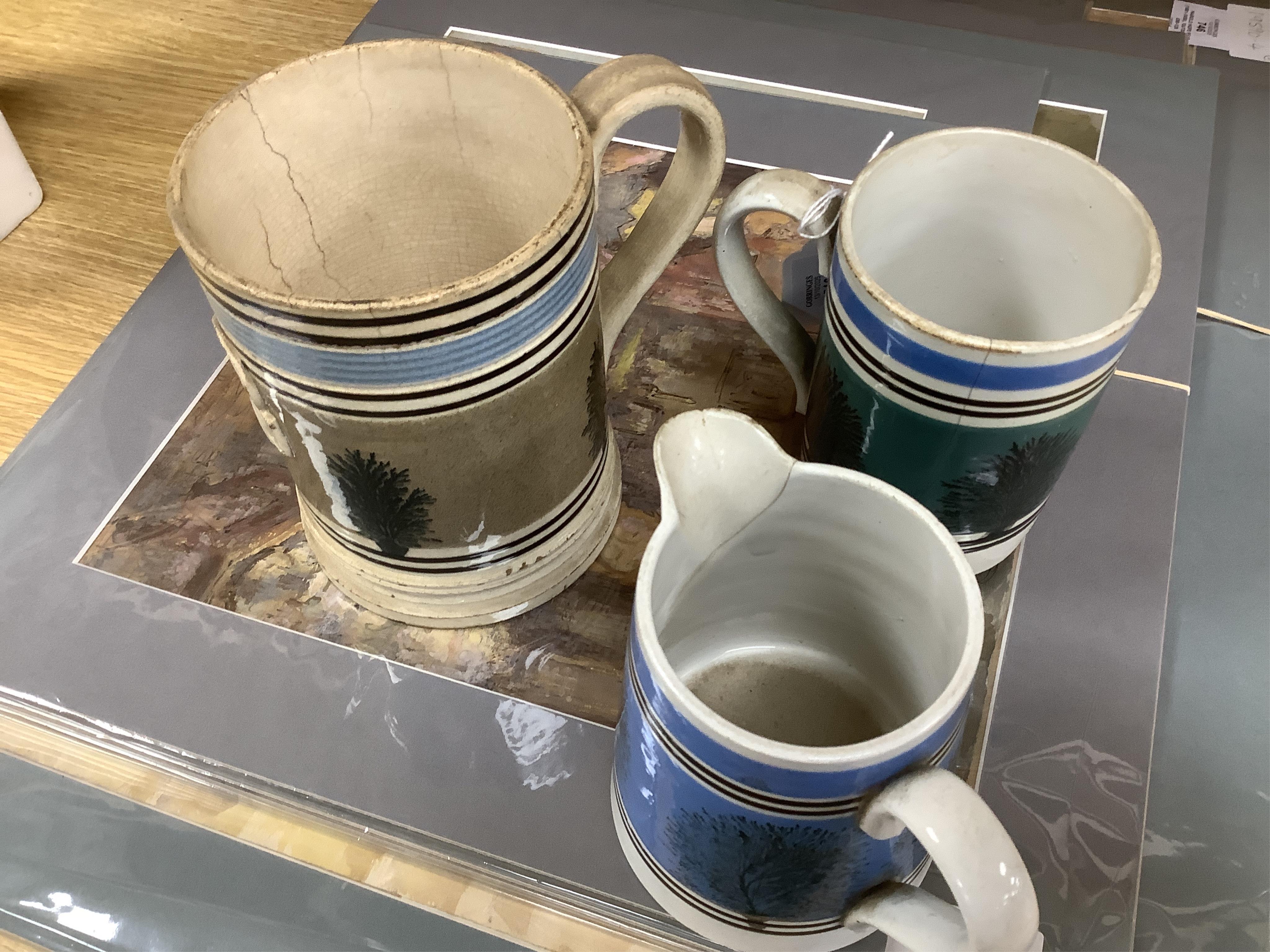 Two early 19th century Mocha ware jugs and two mugs, largest 16cm high